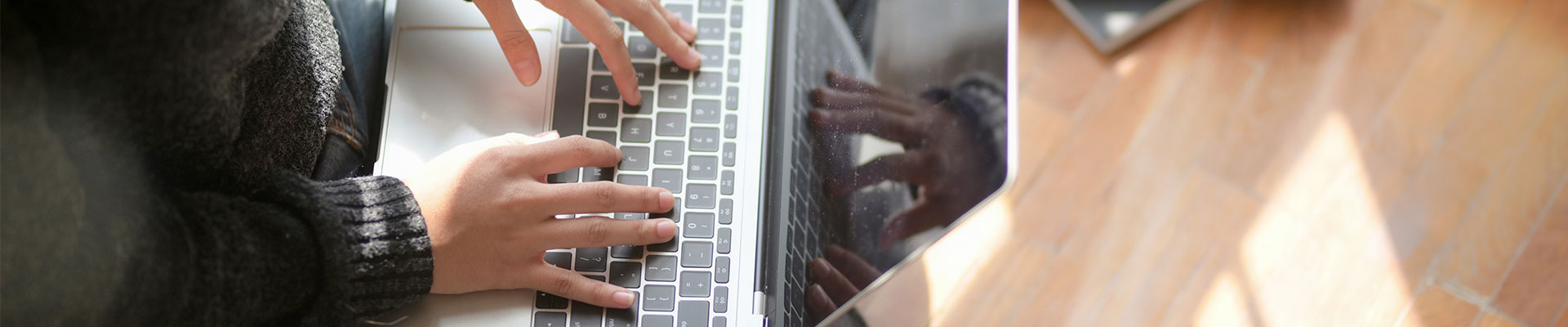 Manos sobre teclado laptop